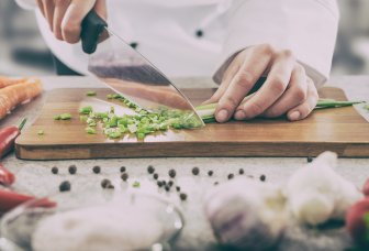 Foto: kok skærer grøntsager.