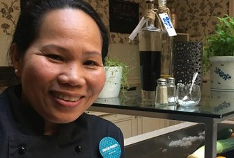 Foto: køkkenchef med urter og grønt i baggrunden.